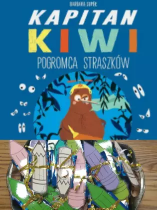 Okładka książki pt. „Kapitan Kiwi Pogromca Straszków” oraz koszyczek przygotowanych upominków.