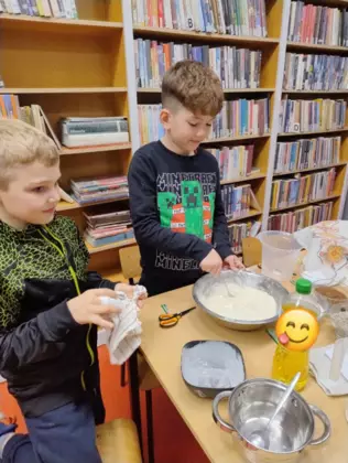Chłopcy mieszają w misce składniki na chleb.