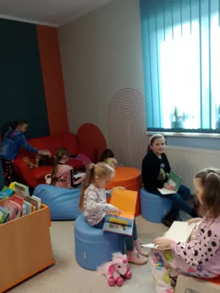 Dzieci przeglądają książeczki związane z tematyką psów.