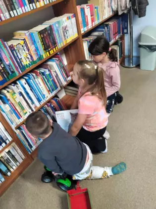 Dzieci szukają ciekawych książeczek do czytania.
