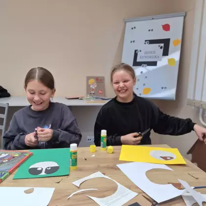 Dwie śmiejące się dziewczyny wycinające z papieru.