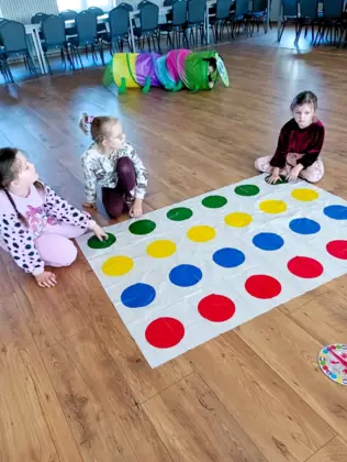 Dzieci grają w Twistera (grę, którą biblioteka w Lisowicach otrzymała w ramach daru.