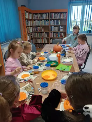 Uczestnicy zajęć w trakcie malowania papierowych talerzyków.