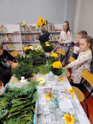 Dzieci wykonują stroiki na Wszystkich Świętych.