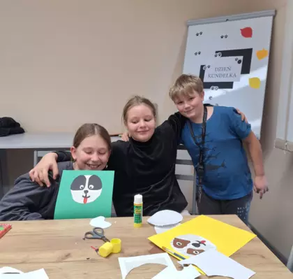 Dziewczyny i chłopak pokazują swojego kundelka.