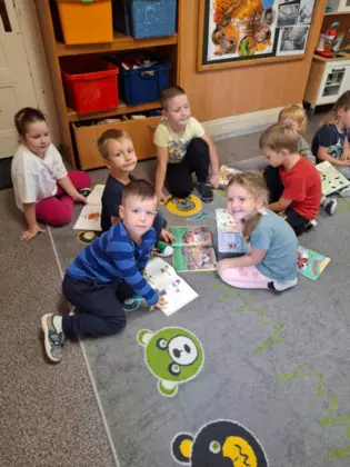 Przedszkolaki przeglądają książeczki.