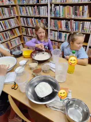 Dziewczynki mieszają w misce składniki na chleb.