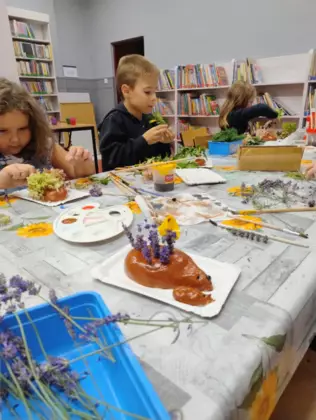 Dzieci oklejają pomalowane farbami jeże.