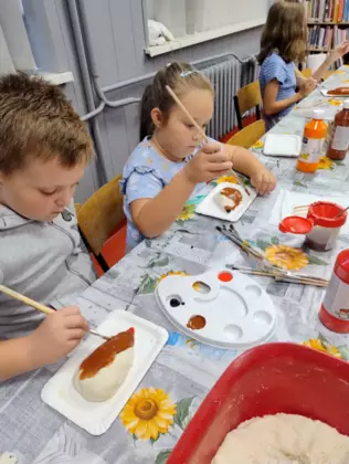 Dzieci malują farbkami.