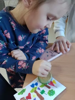 Dziewczynka przybija pieczątkę na list.