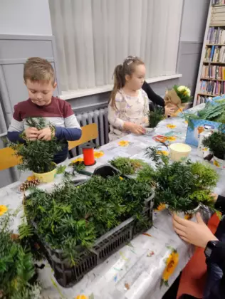 Dzieci wykonują stroiki na Wszystkich Świętych.