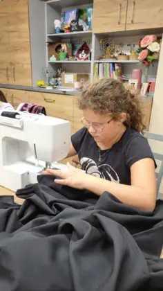 Dziewczyna szyje spódnicę przy maszynie.