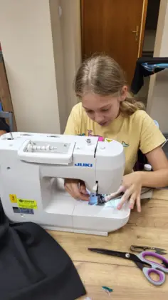 Skupiona dziewczyna szyje przy maszynie.