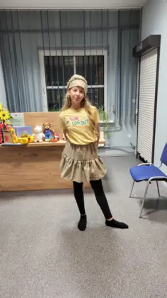 Uśmiechnięta dziewczyna pozuje w spódniczce w bibliotece.