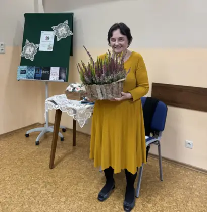 Ksawera Kudlek trzyma w rękach bukiet wrzosów, otrzymany podczas spotkania w Bibliotece w Pawonkowie.