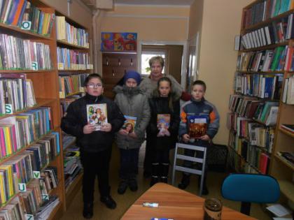 Wspólne zdjęcie dzieci w bibliotece trzymające w ręce nagrody za udział w konkursie