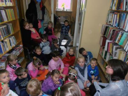Przedszkolaki słuchają bajeczki czytanej przez panią bibliotekarkę