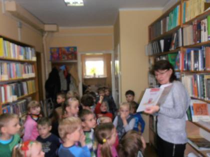 Przedszkolaki słuchają bajeczki czytanej przez panią bibliotekarkę
