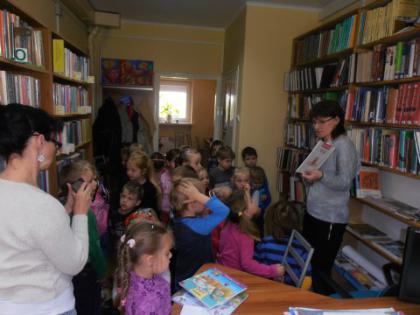Przedszkolaki słuchają bajeczki czytanej przez panią bibliotekarkę