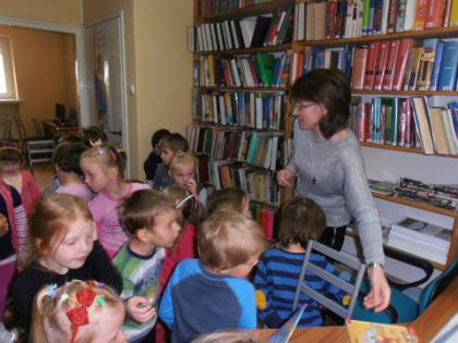 Przedszkolaki słuchają bajeczki czytanej przez panią bibliotekarkę