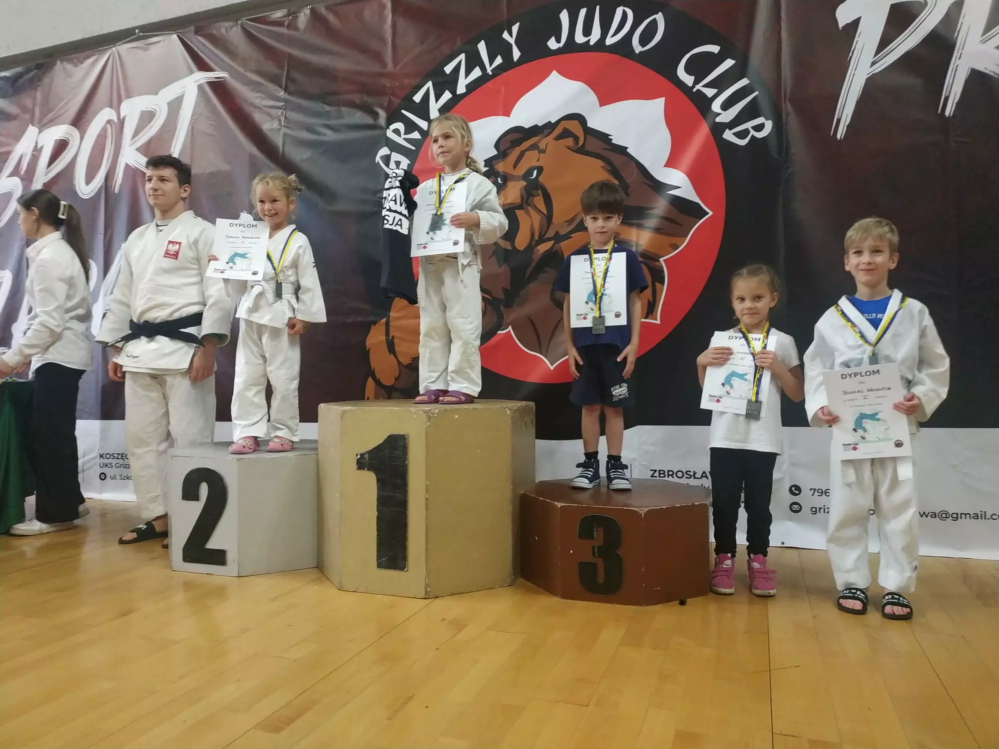Dzieci na zawodach Judo stoją na podium.