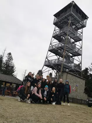 Metalowa wieża widokowa. Grupa młodzieży pozuje do zdjęcia.