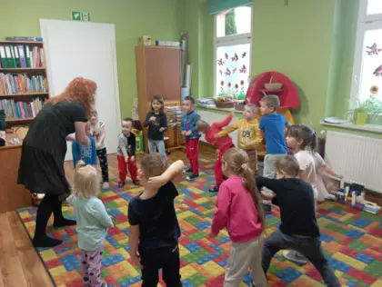 Dzieci bawią się na dywanie w gry ruchowe.