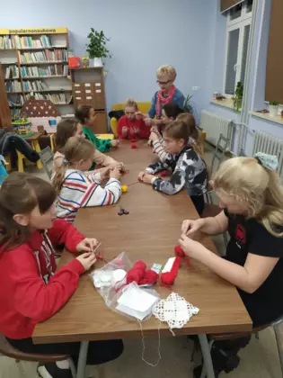 Młodzież szydełkuje w bibliotece.