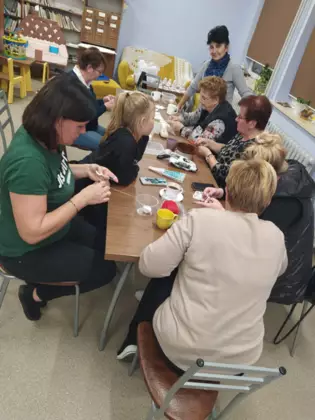 Uczestniczki szydełkują w bibliotece.