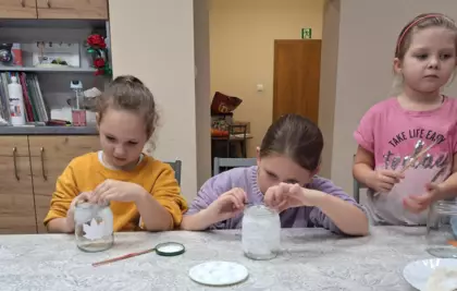 Dziewczynki ozdabiają słoiczki.