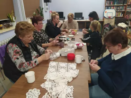 Panie tworzą prace na szydełku w bibliotece.