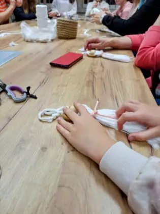 Uczestniczki tworzą ozdoby z makramy.