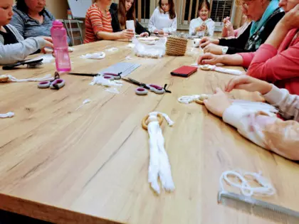 Uczestnicy tworzą ozdoby z makramy.