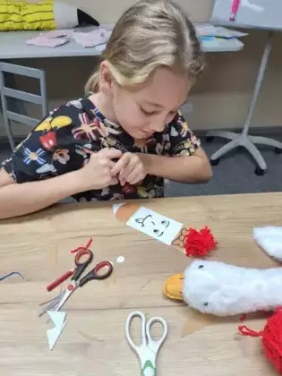 Dziewczynka ozdabia swoją kredkowa zakładkę do ksiązki.