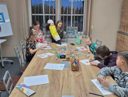 Dzieci malują obrazki różnymi rodzajami kredek.