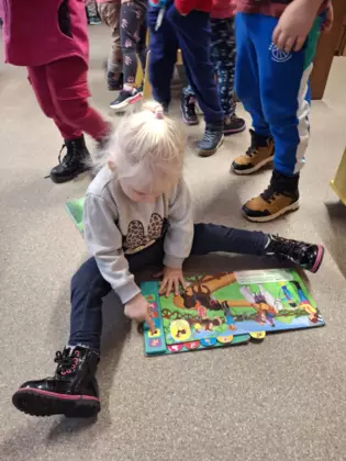 Dziewczynka ogląda książeczkę.