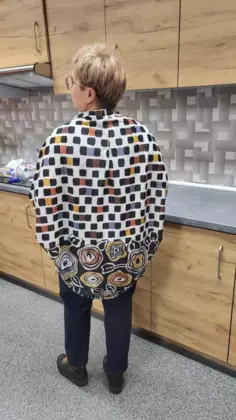 Uczestniczka zajęć ubrana w  kardigan uszyty podczas zajęć.