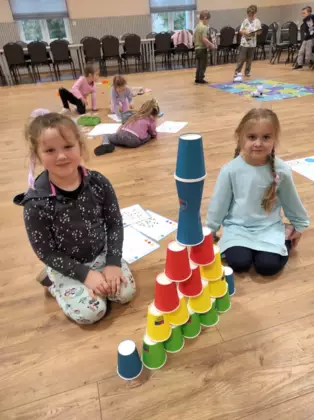 Dziewczynki ułożyły kolorowe kubeczki według podanego wzoru.