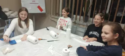 Uczestnicy wykonują aniołki ze sznurka.