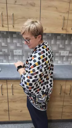 Uczestniczka zajęć ubrana w kardigan uszyty podczas zajęć z szycia.