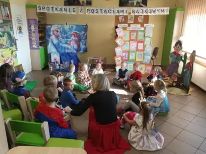 dzieci siedzą wokół Pani bibliotekarki