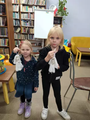 Dwie dziewczynki pokazują wykonane przez siebie aniołki.