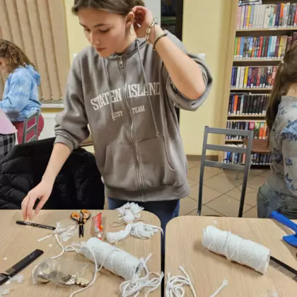 UCzestniczka w trakcie tworzenia makramowego aniołka.