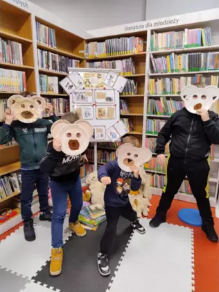 UCzestnicy zajęć pozują z misiowymi maskami.