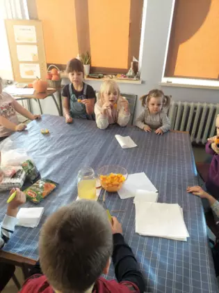 Dzieci jedzą kawałki ugotowanej dyni.