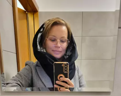 Uczestniczka pokazuje uszyty przez siebie kominoszal.