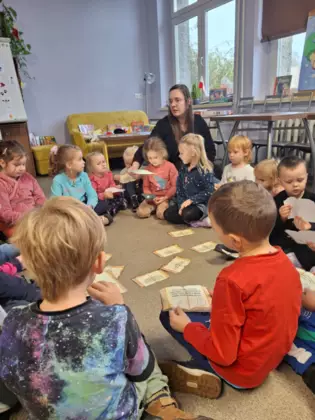 Przedszkolaki rozwiązują zagadki razem z Panią bibliotekarką.