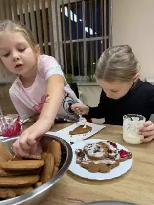 Dziewczynki lukrują pierniki.