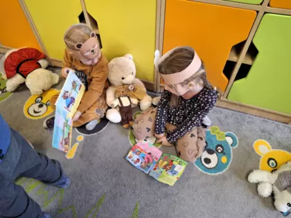 Dzieci przeglądają książeczki o tematyce misiowej.