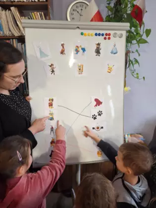 Dzieci łączą postać z bajki z jej atrybutem na tablicy magnetycznej.